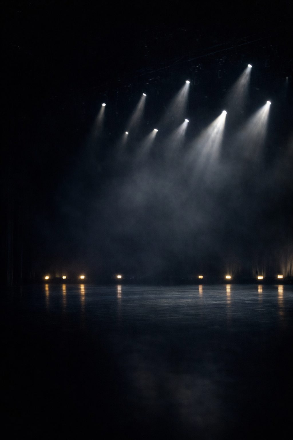 Beams of moving light sweeping across a dark theatre stage